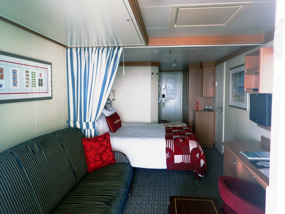 This is Disney Dream room 7128 which is a category 4C Deluxe Family Oceanview Room with a Verandah. It is midship on the port side and connects to room 7126, which is also a 4C. It sleeps 5 people with a queen bed, twin sofa bed, ceiling bunk (right above the sofa) and murphy bed (right in front of the verandah door).