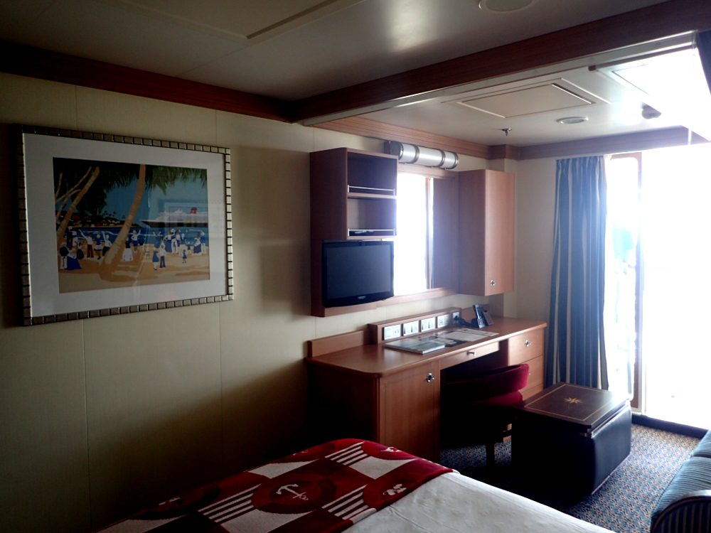 This is Disney Dream room 7128 which is a category 4C Deluxe Family Oceanview Room with a Verandah. It is midship on the port side and connects to room 7126, which is also a 4C. It sleeps 5 people with a queen bed, twin sofa bed, ceiling bunk (right above the sofa) and murphy bed (right in front of the verandah door).